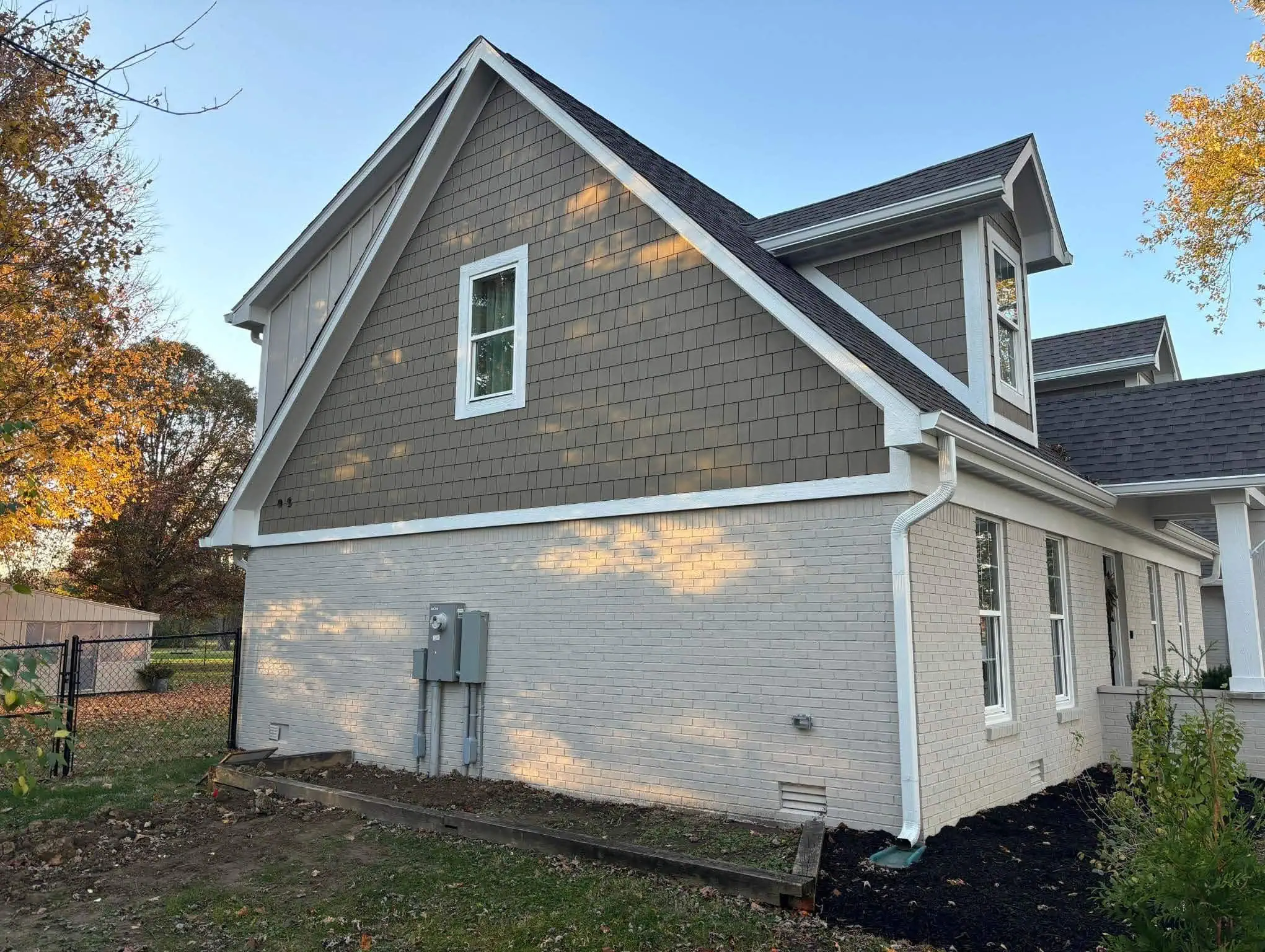 House with freshly painted siding and brick, showcasing professional exterior painting services.